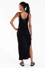 Vestido largo negro de punto con hilo lurex brillante, sin mangas, con escote redondo y aberturas laterales.