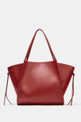 Bolso tipo shopper color rojo de hombro, con detalle de lazos en los laterales y doble asa.