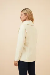 Chaquetón de lana con doble botonadura frontal, solapas anchas y bolsillos de parche delanteros. Presenta un diseño estructurado con forro interior al tono.