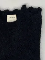 Sweater de punto calado confeccionado en 100% mohair italiano, con cuello redondo y mangas largas. Presenta una textura aireada y delicada con un diseño etéreo y sofisticado.