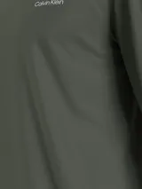 Remera verde militar de manga larga con cuello perkins y logo de Calvin Klein bordado en el pecho.