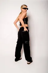 Pantalón cargo de pana negro con bolsillos laterales con solapa y cintura elástica.