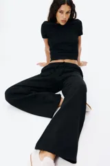 Pantalón tipo jogger de felpa color negro, con cintura elástica ajustable mediante cordón. Presenta un corte amplio y recto en las piernas, con bolsillos laterales discretos.