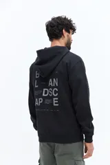 Canguro de algodón y poliéster en color negro, con capucha ajustable y puños elásticos. Presenta un diseño gráfico tipográfico en la espalda con las palabras 'Balance' y 'Landscape' en color gris claro.