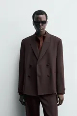 Blazer de traje cruzada de corte regular fit, color marrón oscuro, con solapas de muesca, bolsillos de doble vivo en la cadera y cierre frontal de botonadura doble.
