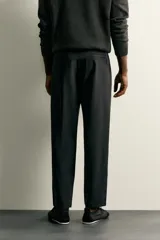 Pantalón regular fit de hombre color negro, confeccionado en tejido técnico ligero con cintura elástica, bolsillos frontales, bolsillos traseros de vivo y cierre frontal con cremallera y botón.