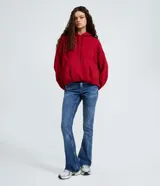 Pantalón flare de jeans azul, con cintura mediana, trabillas para cinturón, cierre frontal de cremallera y botón, y diseño de cinco bolsillos.