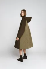 Parka oversize de corte recto confeccionada en tejido con mezcla de lana en color verde oliva. Presenta cuello alto con capucha, cierre frontal con botones y bolsillos laterales. Incluye detalles en tejido acolchado a contraste en la solapa frontal y puños.