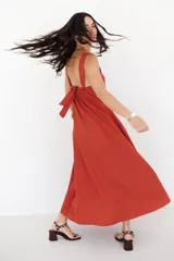 Vestido largo de corte holgado en color azul, con escote en V, breteles regulables y bolsillos laterales. Presenta un delicado diseño de flores bordadas en el lateral inferior.