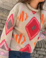 Sweater gris tejido a mano con diseño geométrico multicolor y detalles bordados, de manga larga y corte holgado.