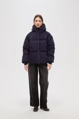 Campera puffer de color marrón oscuro, con diseño capitoneado, cierre frontal, capucha ajustable y bolsillos laterales con cierre.