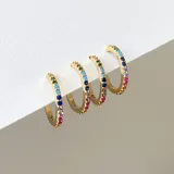 Par de aros dorados tipo argolla con incrustaciones de cristales de colores. Fabricados en acero con baño de oro de 18k y cristales Cubic Zirconia.