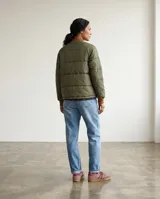 Campera bomber con diseño de paneles combinados: mangas y espalda en color verde oliva acolchado, y frente con paneles laterales estampados en tonos tierra y violeta. Presenta cuello, puños y ruedo en tejido de punto acanalado color marrón, con cierre frontal completo.