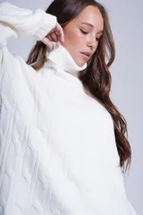 Sweater tejido color crudo con cuello alto y diseño de ochos.