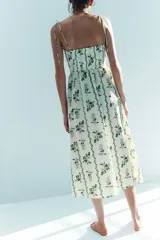 Vestido midi en popelina de algodón blanco con estampado floral y de enredaderas verdes, escote corazón, tirantes finos con lazo y falda con vuelo.
