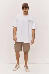 Remera oversize blanca de manga corta, con corte amplio y estampa gráfica pequeña en el pecho.