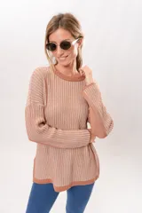 Sweater de punto color salmón con rayas verticales en relieve. Tiene cuello redondo y corte holgado.