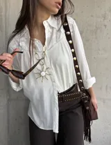 Camisa blanca de manga larga con detalles bordados en el canesú y cuello clásico.