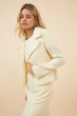 Chaqueta de lana fina sin teñir, color marrón claro, de corte recto con cuello solapa y mangas 3/4.