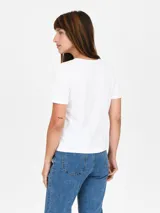 Remera blanca de mangas cortas con detalle de abertura circular en el ruedo.