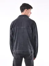 Campera de jean negra con lavado oscuro, corte oversize y cuello camisero. Presenta bolsillos grandes con tapa y botón en el pecho.