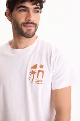 Remera blanca de manga corta y cuello redondo, confeccionada en 100% algodón, con un pequeño estampado minimalista en marrón en el pecho que incluye figuras geométricas, una palmera y olas.