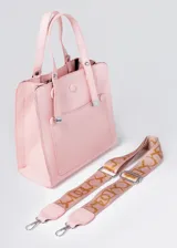 Cartera rosa de cuero sintético con doble asa corta y correa larga extraíble con estampado de letras doradas.