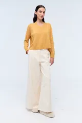 Sweater de tejido de punto color beige, con escote en V y calce holgado.