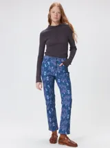 Pantalón de jean de tiro medio con corte de pierna recta y ajuste cómodo. Presenta un estampado integral con motivos geométricos y abstractos en tonos azules.