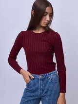 Top de punto ajustado al cuerpo, color bordó, con cuello redondo y mangas largas. Presenta un diseño acanalado vertical con costuras decorativas que forman una silueta en el frente.