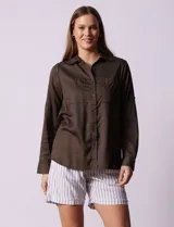 Camisa color verde militar de lyocell, marca Cyrus. Cuello con solapa, abertura central con botones y bolsillos aplicados en el pecho. Mangas largas regulables con presilla y botón.