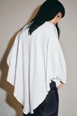 Camiseta tipo capa color negro de algodón Supima 100%, con escote en V, manga larga fluida y bajo asimétrico.