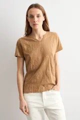Remera marrón camel de manga corta, con cuello en V y diseño de estampado floral con relieve.