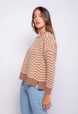 Sweater tejido con diseño de líneas triangulares en distintos tonos con puños en las mangas.
