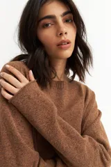 Sweater azul petróleo de tejido de punto, con cuello redondo y botones decorativos en los laterales.