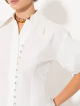 Camisa celeste de popelina, de silueta amplia y diseño liviano. Incluye cuello clásico y cierre frontal con botones.