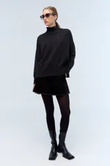 Polera tejida de punto confeccionada en lambswool color gris claro, con cuello alto y calce holgado.