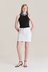 Minifalda de jean Levi's en color blanco, con diseño deconstruido, tiro medio y cierre frontal con botones y cremallera.