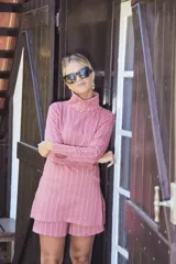 Remera de cuello alto color rosa viejo con rayas verticales blancas y mangas largas.