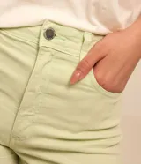 Short de sarga color blanco, de cintura alta, con bolsillos delanteros y traseros, trabillas para cinturón y bajo plegado. Cuenta con cierre frontal de botón y cremallera.
