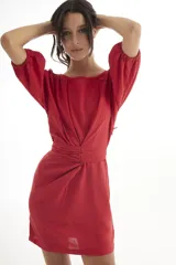 Vestido corto de lino color rojo, con mangas globo y escote redondo. Presenta un corte entallado en la cintura con un lazo ajustable que permite entallar la prenda.