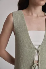 Chaleco largo de punto color verde claro, sin mangas, con escote en V y cierre frontal de lazo.