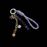 Colgante para cartera con cadena dorada y charms colgantes: frutilla roja, Hello Kitty rosa, cerezas con strass y cordón trenzado rosa.