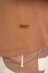 Sweater color marrón claro con textura tipo waffle, corte holgado y mangas largas.