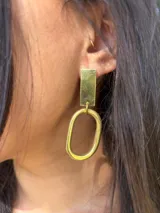 Aretes colgantes de metal plateado, compuestos por un rectángulo superior y un óvalo texturizado inferior.