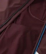 Campera deportiva Get Over de hombre, color bordó, con capucha ajustable, cierre frontal y bolsillos con cremallera. Confeccionada en tejido técnico resistente al agua.
