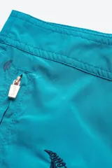 Short de baño azul con estampado de palmeras, de corte clásico y cintura fija.