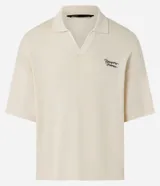 Camisa polo de hombre confeccionada en tejido de punto de algodón, color crema, con cuello en V y manga corta. Presenta un corte oversized y un pequeño bordado de lettering en el pecho.