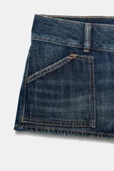 Shorts mini de denim tiro bajo, con bolsillos de plastrón delanteros y traseros, trabillas para cinto y cierre frontal con cremallera y doble botón metálico.