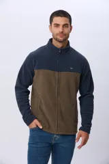 Campera polar bicolor de diseño texturado suave al tacto, con cuello alto, cierre frontal completo y bolsillos laterales. Presenta una combinación de color azul marino en la parte superior y marrón en la inferior, con un pequeño logo bordado en el pecho.